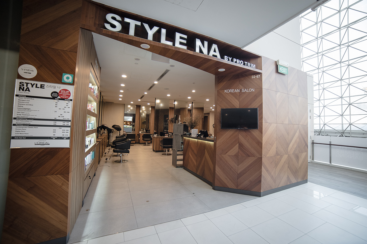 Interior of the Parkway Parade hair salon with warm timber styling stations and mirrors