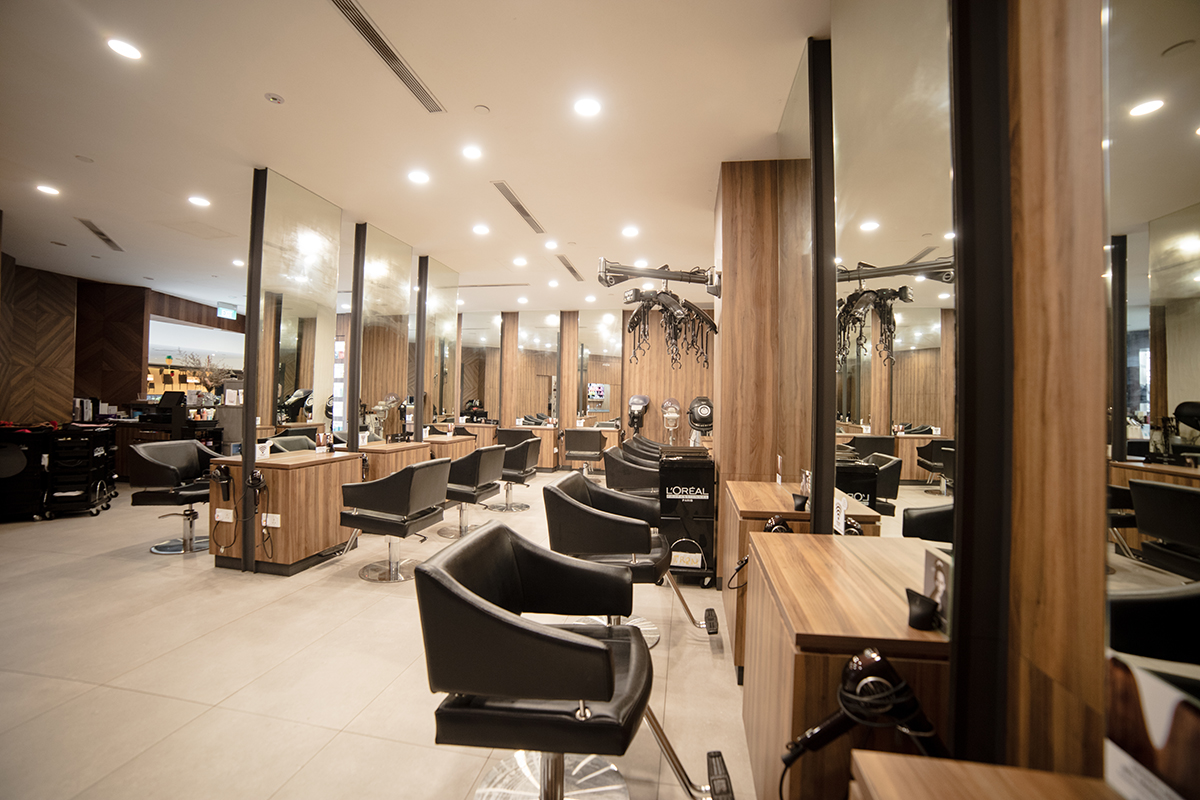 Salon waiting area with timber bench seating and concrete tile flooring