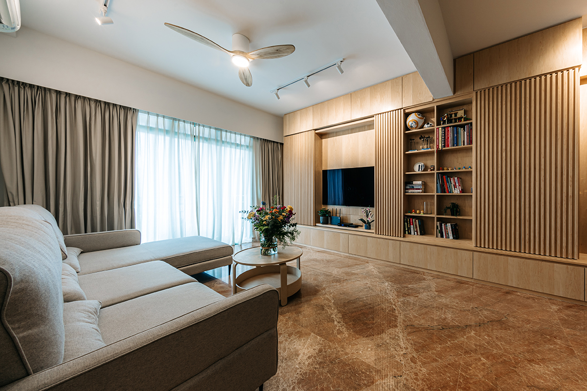 Open-plan living and dining area in warm timber with spare, low furniture