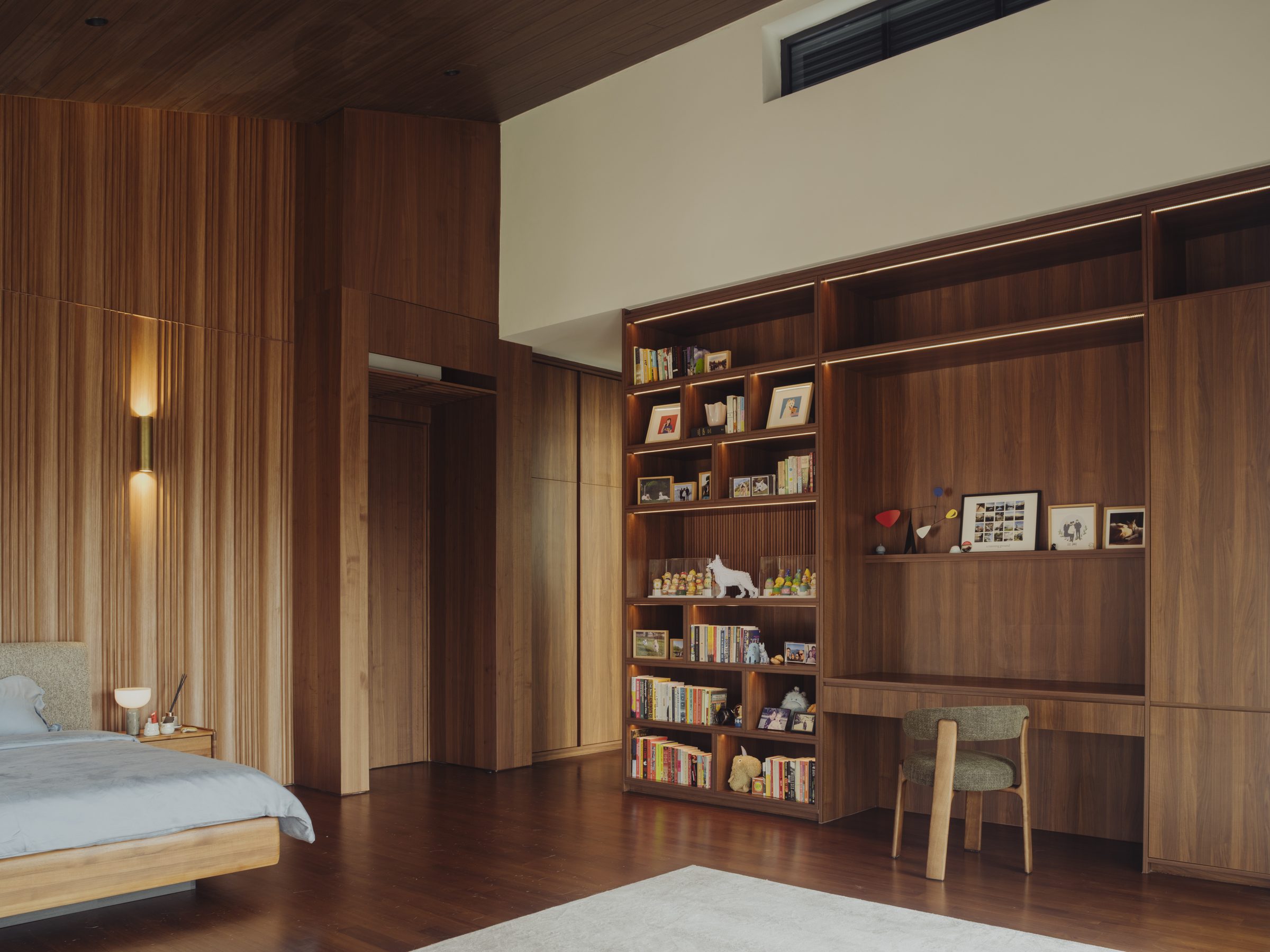 Bedroom looking toward the bookcase and study nook, timber floor and soft daylight