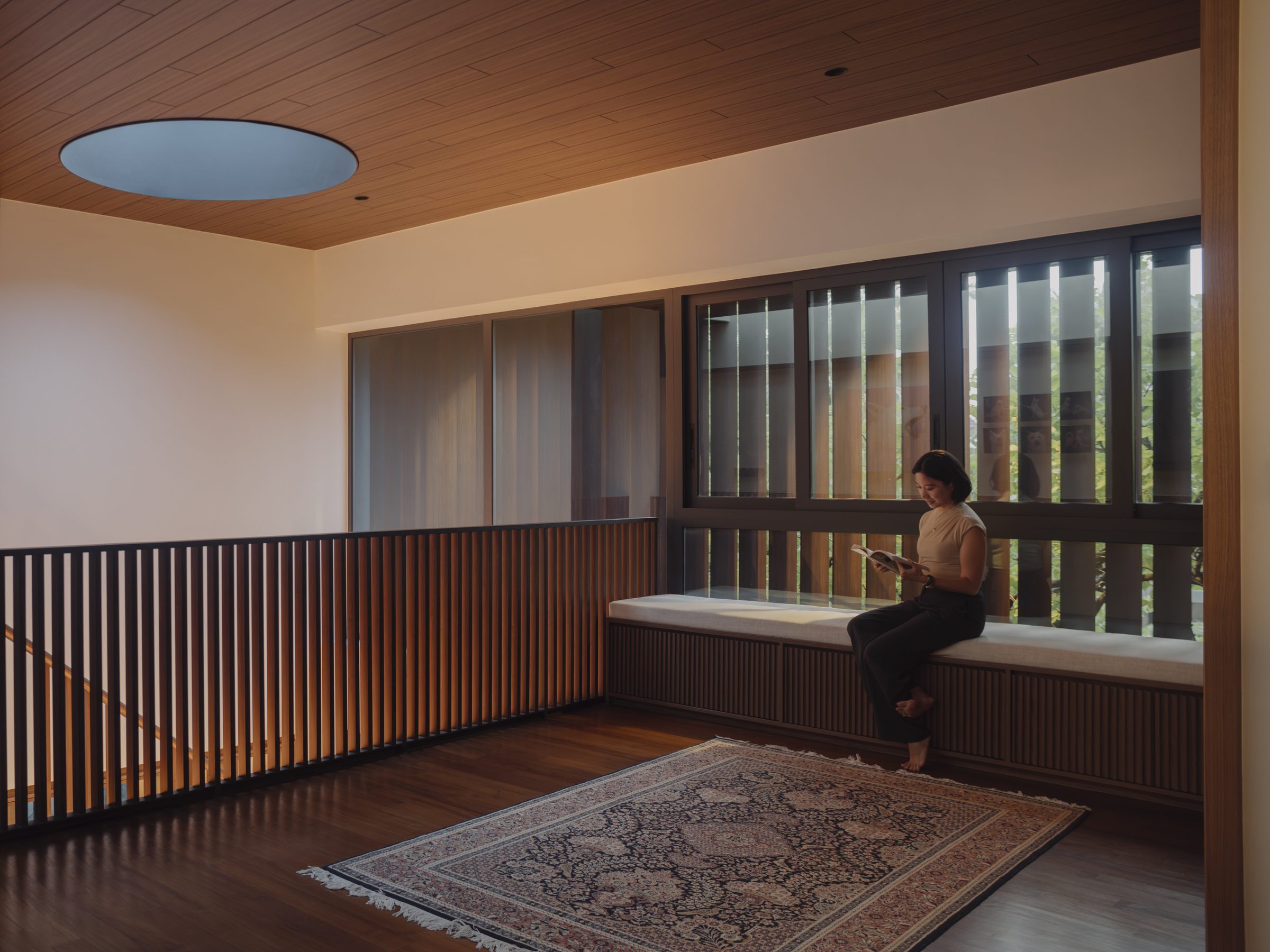Family area with a built-in window seat along the timber-screened windows