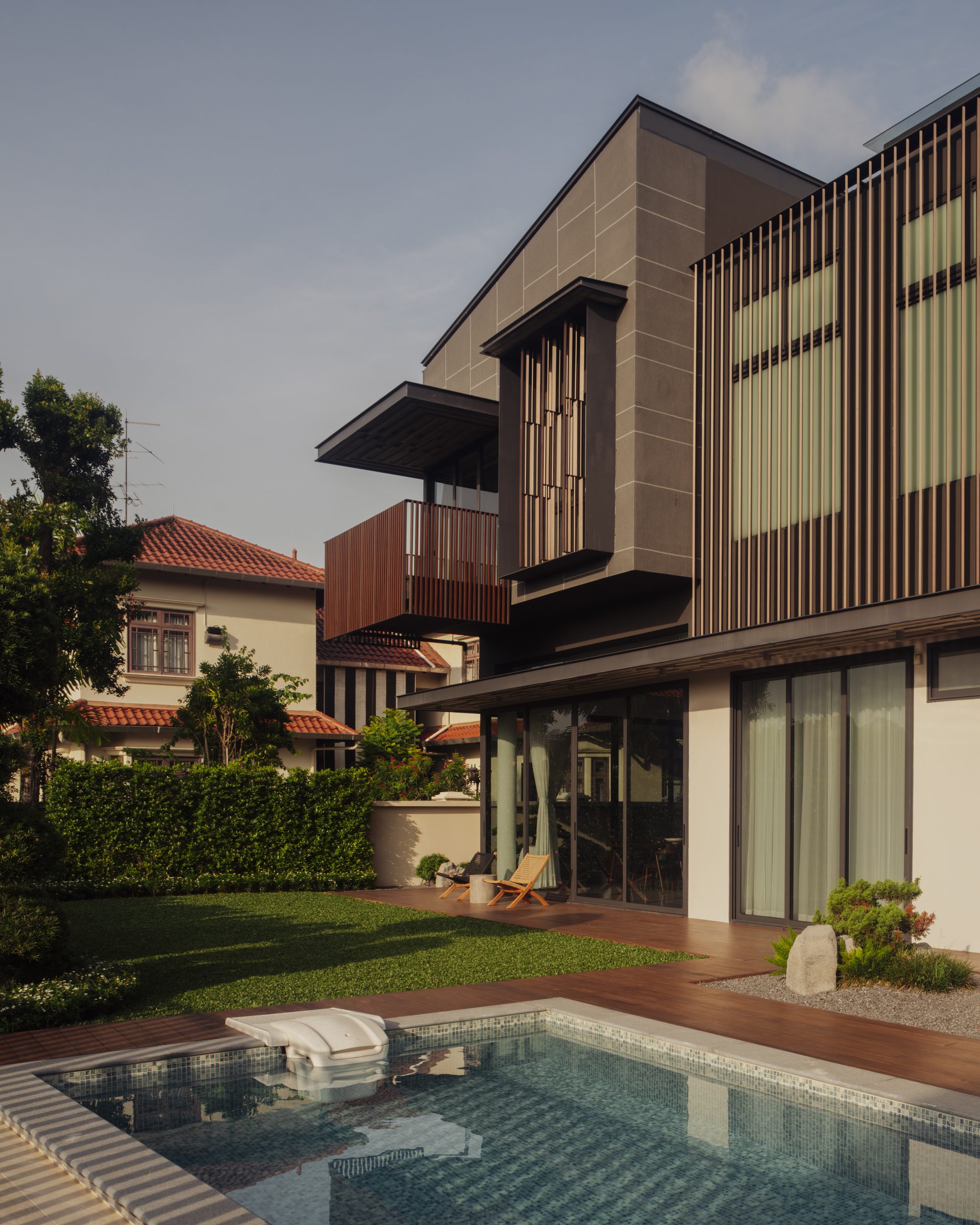 The garden elevation seen across the pool, timber screens and planting along the terrace