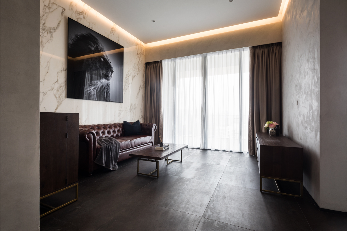 Living area of The Trizon apartment with dark timber and marble finishes