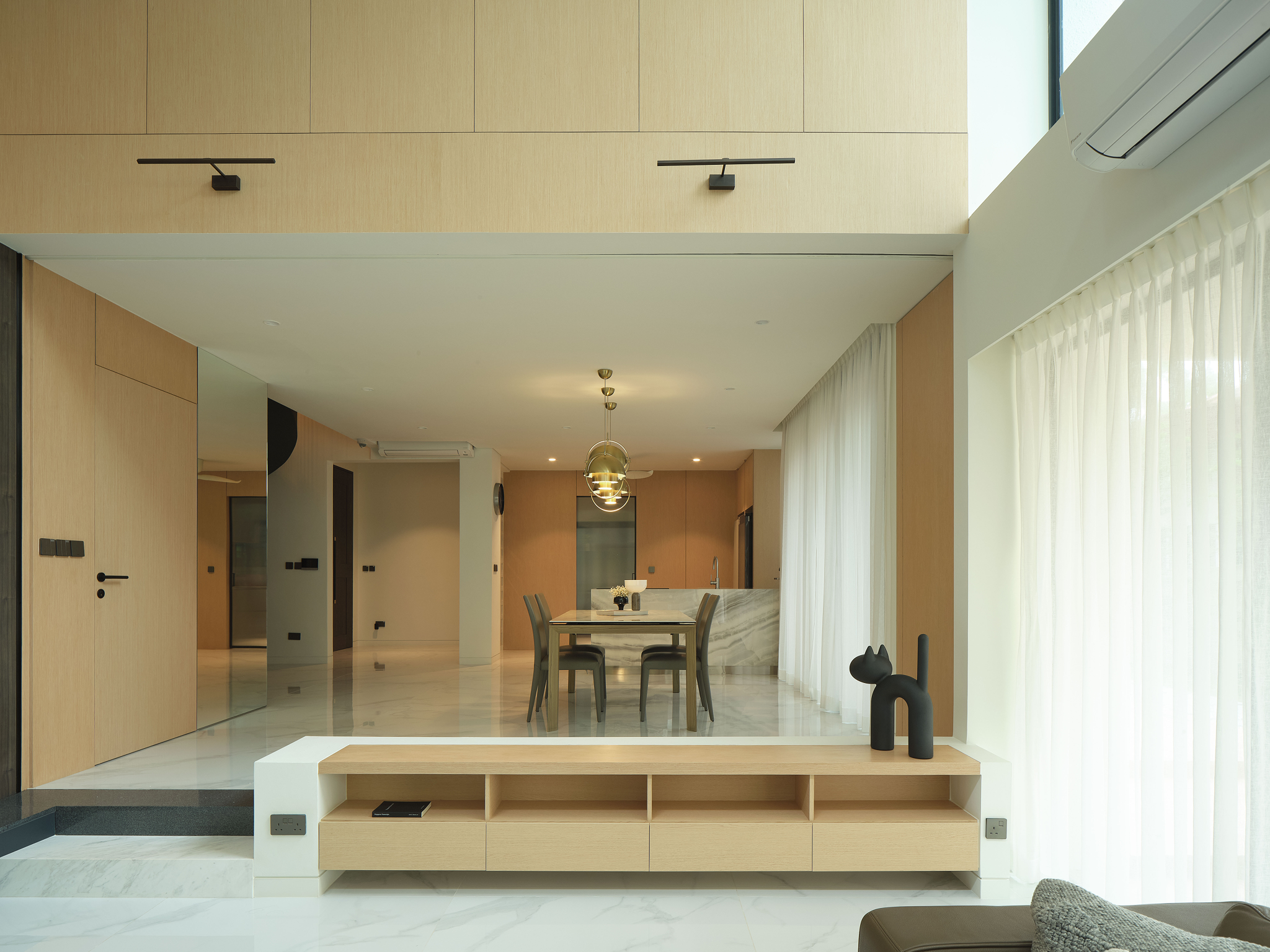 Living and dining space with timber joinery, a marble feature panel and a curtained glazed wall